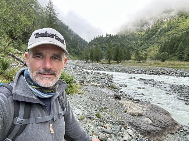 Stefan an einem Bergbach in einem Tal.